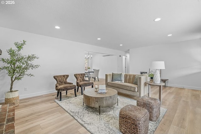 living area with a chandelier, recessed lighting, light wood-type flooring, and baseboards