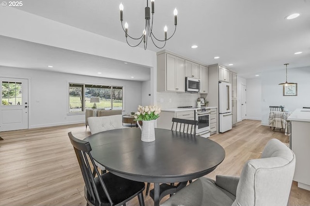 dining room with light wood-style floors, an inviting chandelier, and recessed lighting