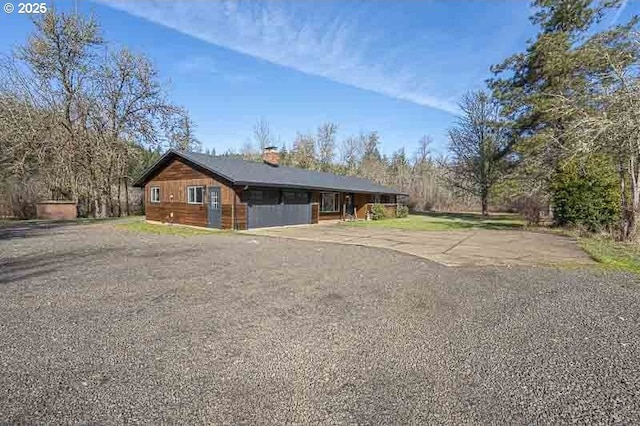 view of front of house with driveway and a chimney