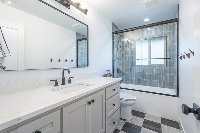 full bathroom featuring shower / bath combination with glass door, vanity, toilet, and tile patterned floors