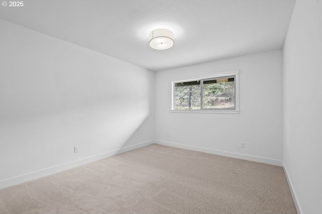 unfurnished room with baseboards and light colored carpet