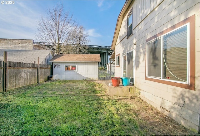 view of yard with a fenced backyard and an outbuilding