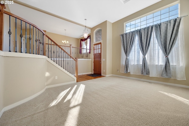 entrance foyer with carpet flooring, a chandelier, and a high ceiling