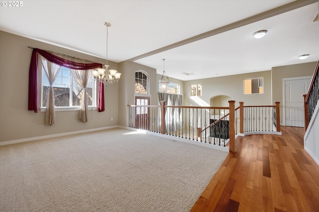 unfurnished room with wood-type flooring and a chandelier