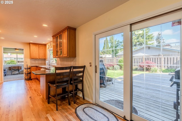 entryway featuring a sink, light wood finished floors, a textured ceiling, recessed lighting, and baseboards