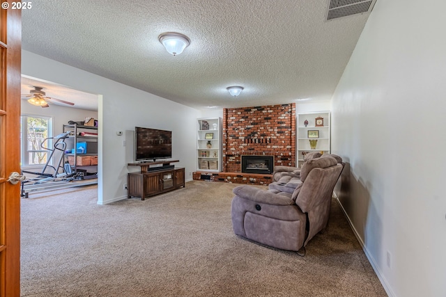 carpeted living room featuring ceiling fan, a textured ceiling, visible vents, a brick fireplace, and baseboards