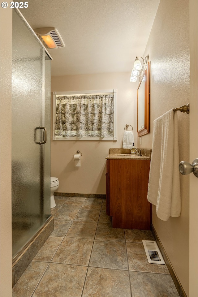 full bath featuring vanity, a stall shower, toilet, and visible vents