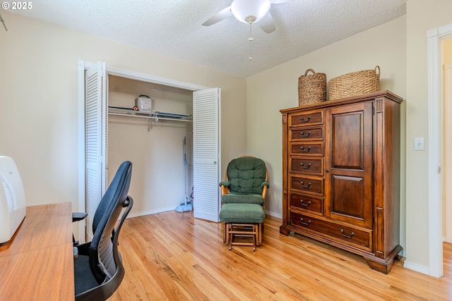office area featuring a textured ceiling, ceiling fan, and light wood-style flooring