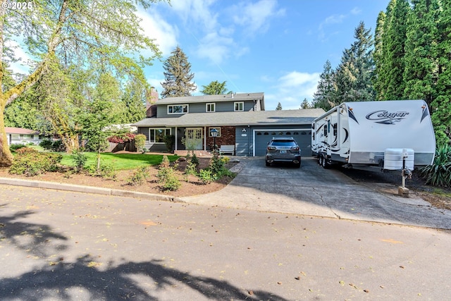 traditional home featuring brick siding, driveway, a chimney, and a garage