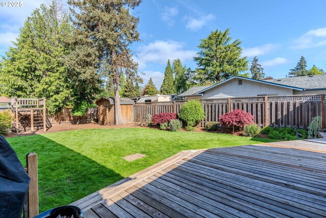 view of yard featuring a fenced backyard, an outbuilding, a storage shed, and a deck