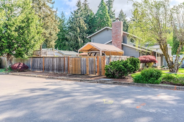 view of property exterior featuring fence and a chimney