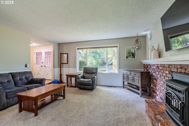 carpeted living area featuring a textured ceiling, a healthy amount of sunlight, and a wood stove