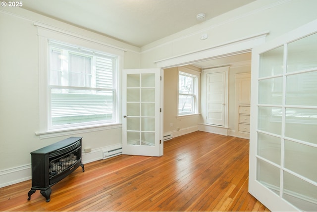 spare room featuring ornamental molding, a baseboard radiator, baseboards, and hardwood / wood-style floors