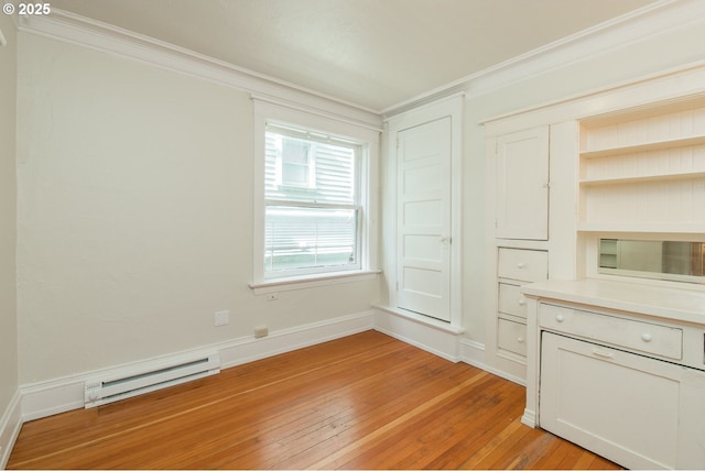 interior space with a baseboard heating unit, ornamental molding, baseboards, and light wood-style floors