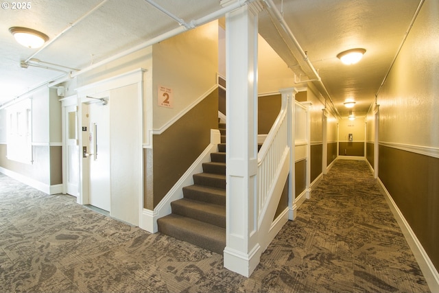 corridor featuring stairway and carpet