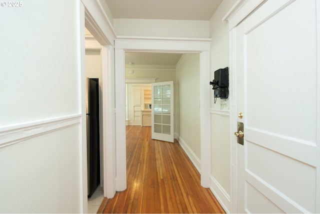 hall featuring hardwood / wood-style floors and baseboards