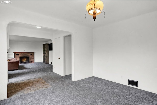 1541 Buckhorn Rd, Roseburg, OR 97470 - unfurnished living room featuring carpet flooring, a fireplace, and arched walkways