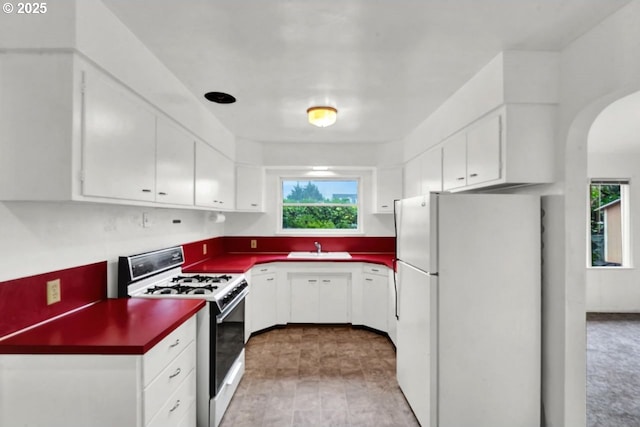 1541 Buckhorn Rd, Roseburg, OR 97470 - kitchen featuring white appliances, dark countertops, arched walkways, and white cabinetry