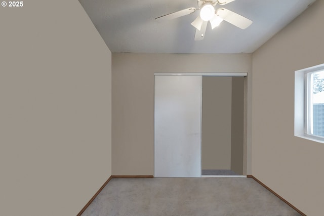 unfurnished bedroom with light carpet, ceiling fan, baseboards, and a closet