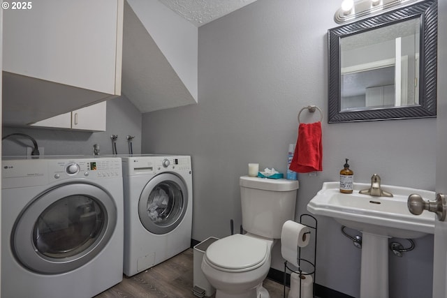 bathroom with wood finished floors, toilet, and washer and clothes dryer