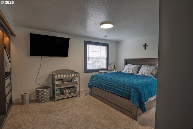 carpeted bedroom featuring a textured ceiling, visible vents, and baseboards