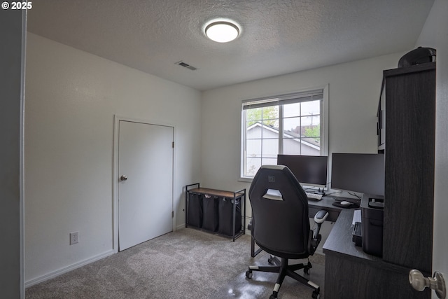 office area with a textured ceiling, visible vents, and carpet
