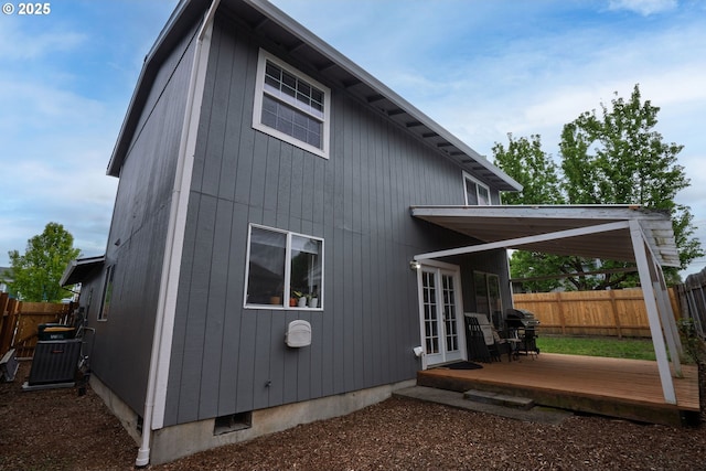 rear view of house with fence, cooling unit, french doors, and a wooden deck