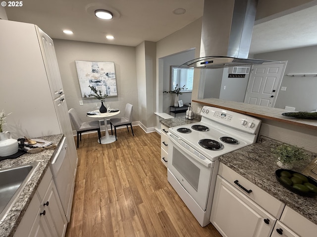 9036 SE Washington St, Portland, OR 97216 - kitchen with white appliances, island exhaust hood, white cabinets, light wood-style floors, and recessed lighting