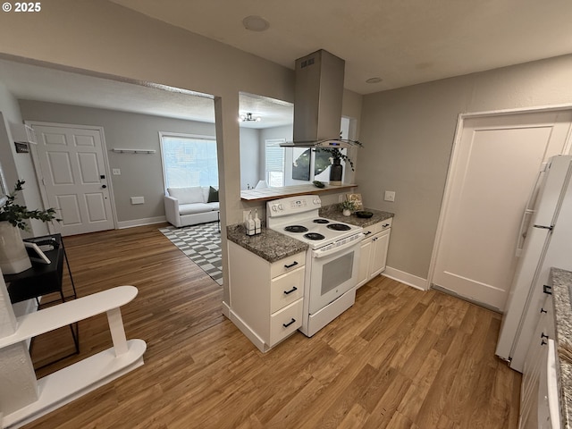 9036 SE Washington St, Portland, OR 97216 - kitchen with white appliances, island range hood, light wood finished floors, white cabinetry, and dark stone counters