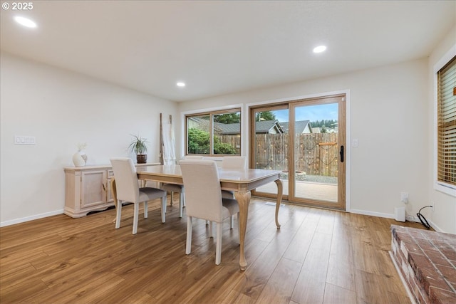 dining area featuring baseboards, light wood finished floors, and recessed lighting