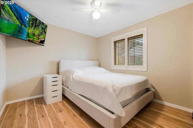 bedroom featuring baseboards, ceiling fan, and light wood-style floors