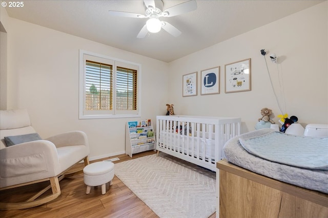 bedroom with ceiling fan, light wood-style flooring, and baseboards