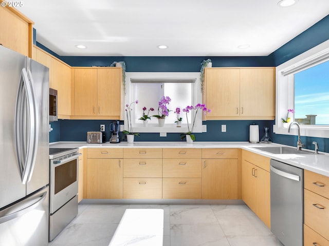 3764 Pacific Ave, Cannon Beach, OR 97110 - kitchen with stainless steel appliances, light brown cabinetry, light countertops, light marble finish flooring, and recessed lighting
