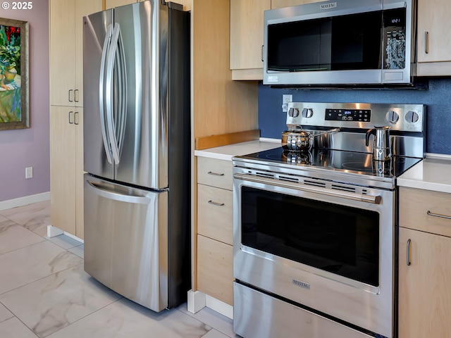 3764 Pacific Ave, Cannon Beach, OR 97110 - kitchen featuring stainless steel appliances, light brown cabinetry, light marble finish flooring, and light countertops