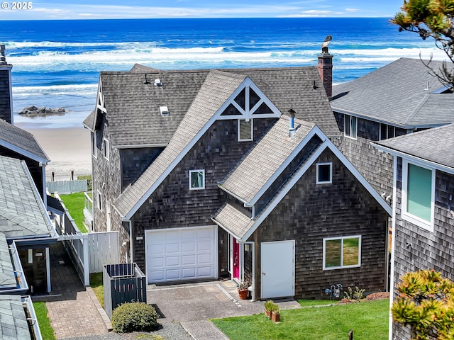 3764 Pacific Ave, Cannon Beach, OR 97110 - view of front of house featuring a shingled roof, a garage, a water view, and a chimney