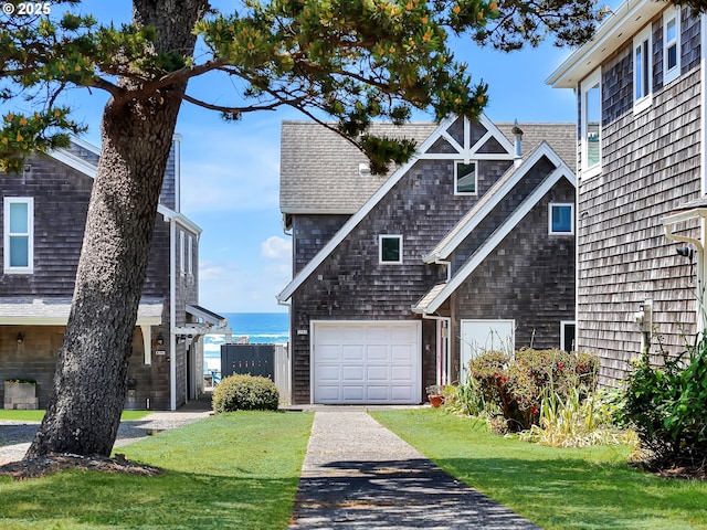 3764 Pacific Ave, Cannon Beach, OR 97110 - view of front of property with a water view, an attached garage, a shingled roof, and a front yard