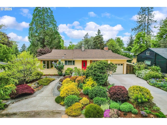 view of front of property with a garage, a chimney, and concrete driveway