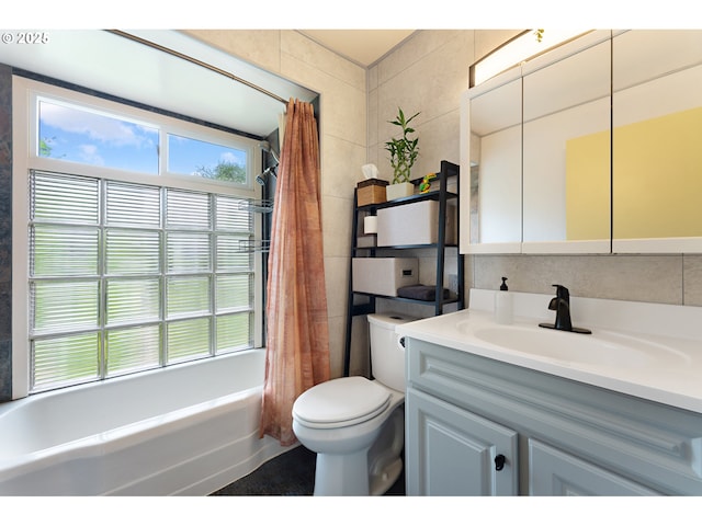 full bath with toilet, tile walls, shower / bath combination with curtain, and vanity