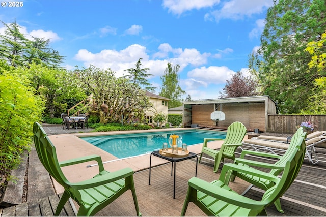 view of pool with a patio, a fenced in pool, fence, and an outdoor structure