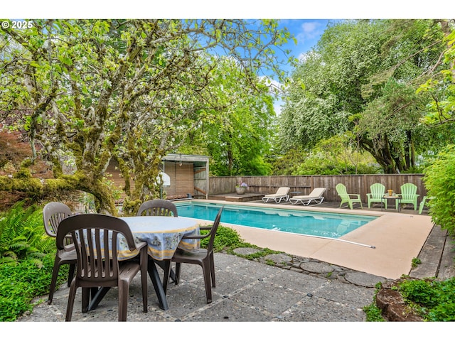 view of pool with a patio, fence, a fenced in pool, and outdoor dining space
