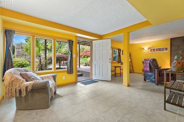 entryway featuring baseboards, a textured ceiling, and light tile patterned floors