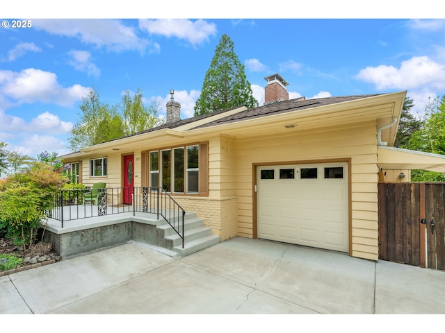 single story home featuring concrete driveway, a chimney, and a garage