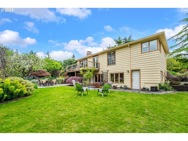 back of house with a patio, a wooden deck, a yard, and a chimney