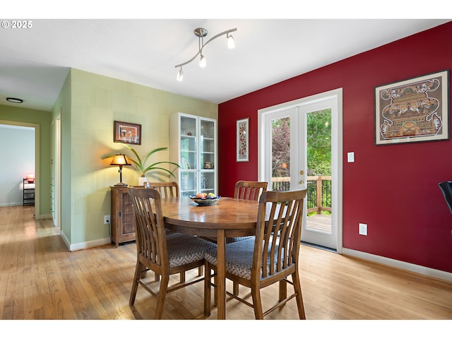 dining room featuring baseboards, french doors, and light wood-style floors