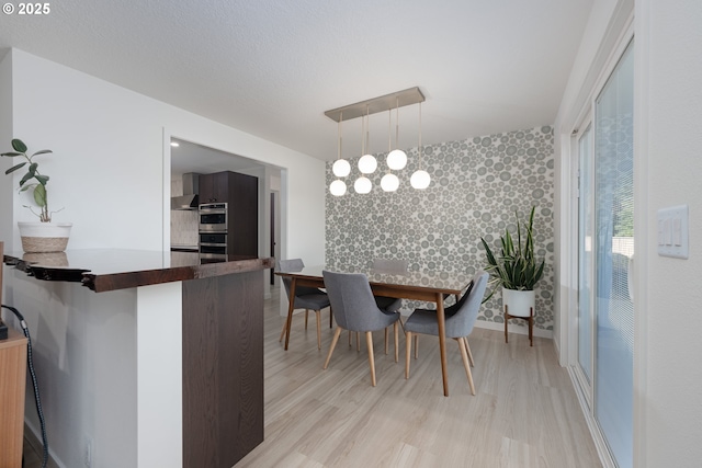 dining room featuring light wood-type flooring and a notable chandelier