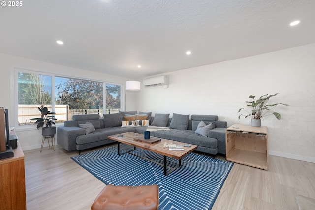 living room with light hardwood / wood-style floors and a wall unit AC