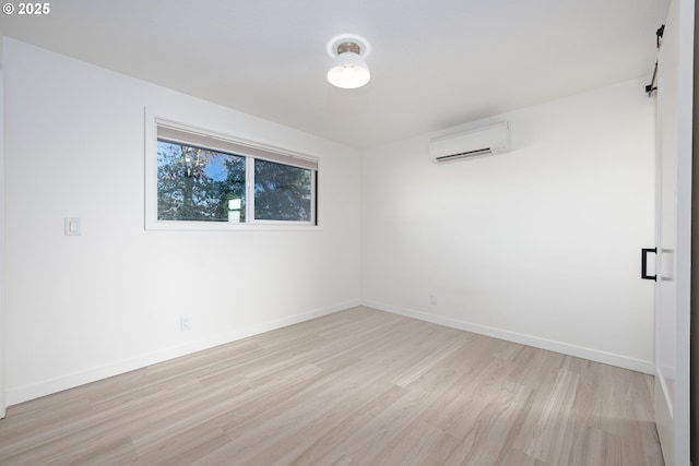 empty room with light hardwood / wood-style floors and a wall unit AC