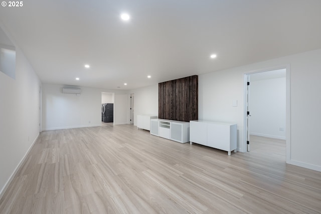 unfurnished living room featuring light wood-type flooring and a wall mounted AC