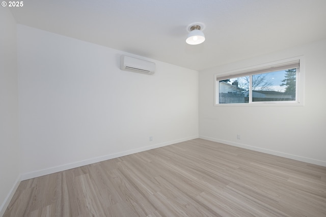 unfurnished room featuring light hardwood / wood-style floors and a wall unit AC