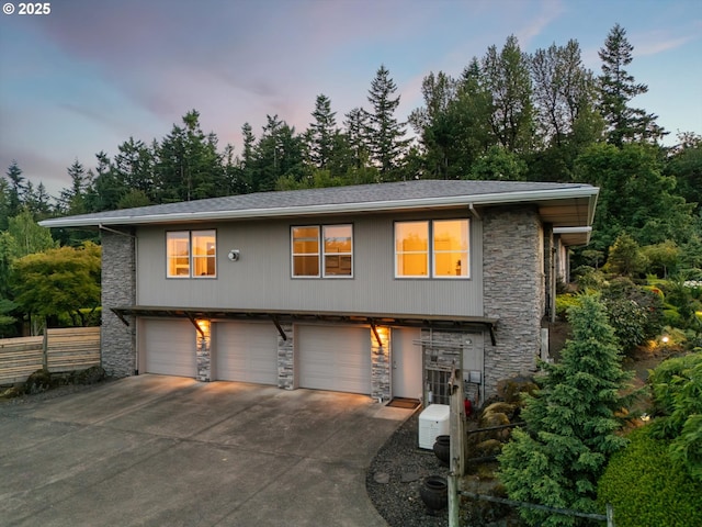 800 Rosemont Rd, West Linn, OR 97068 - view of front of home with stone siding, an attached garage, driveway, and view of scattered trees